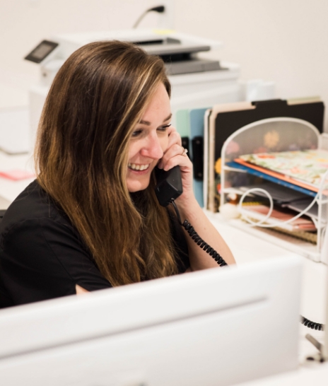 Pediatric dental team member smiling at boy in dental chair