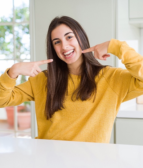 Teen pointing to her teeth