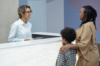 Mother and son talking to a receptionist
