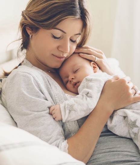 Mother holding sleeping baby against her chest