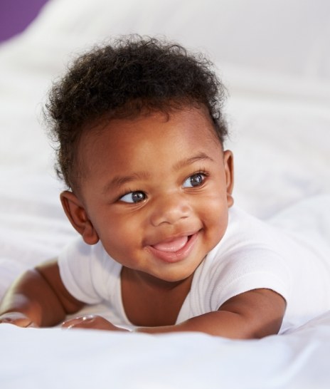 Smiling baby laying on their stomach