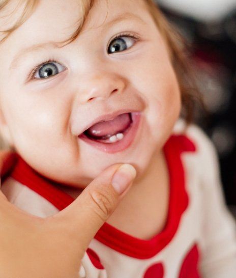 Smiling toddler girl with only two lower front teeth