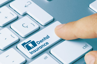 Finger pushing “Dental Insurance” button on computer keybaord