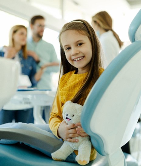 Child giving thumbs up in dental chair