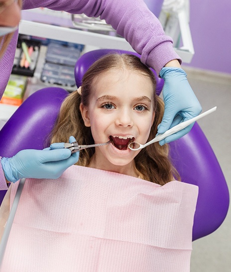 young patient smiling while visiting pediatric dentist