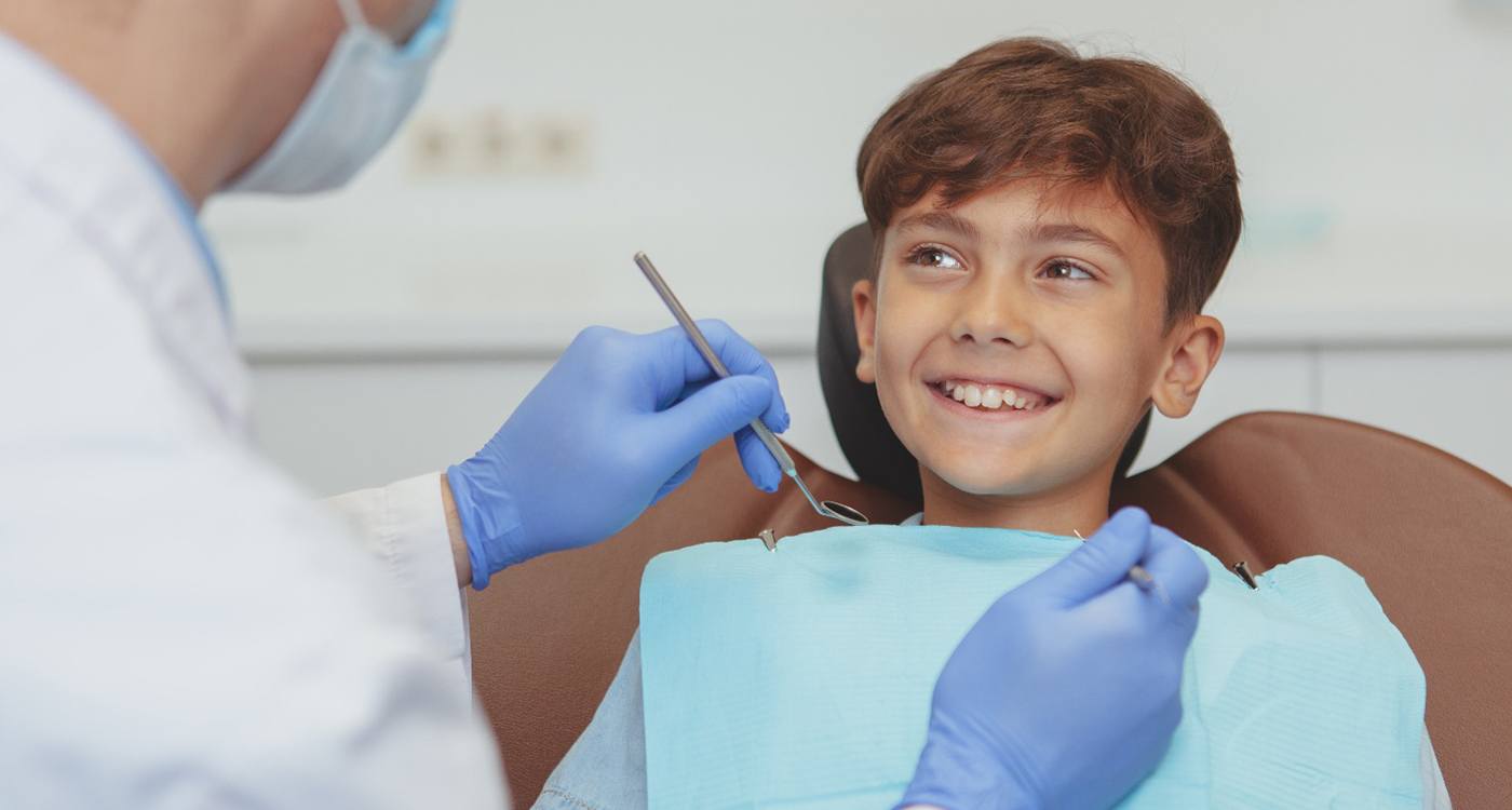 Boy in dental chair smiling about to have teeth examined