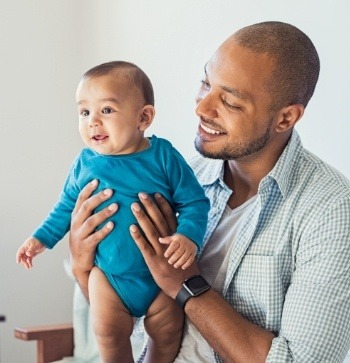 Smiling father holding his baby