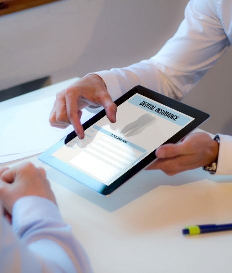 Two people looking at dental insurance information on tablet