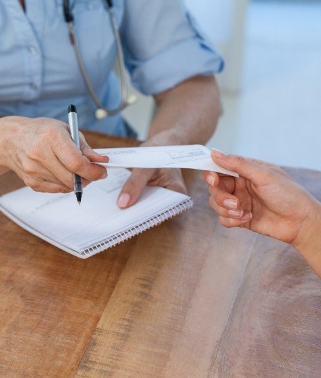 Person handing a check to a person across desk