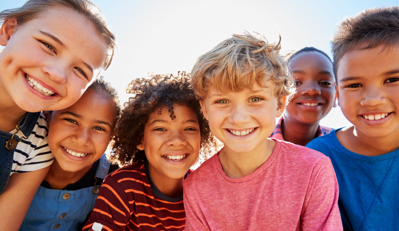 Group of children smiling outdoors after visiting pediatric dentist in Fort Worth