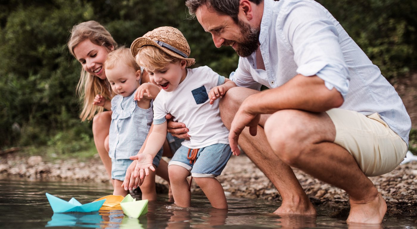 Smiling family of four playing in a river