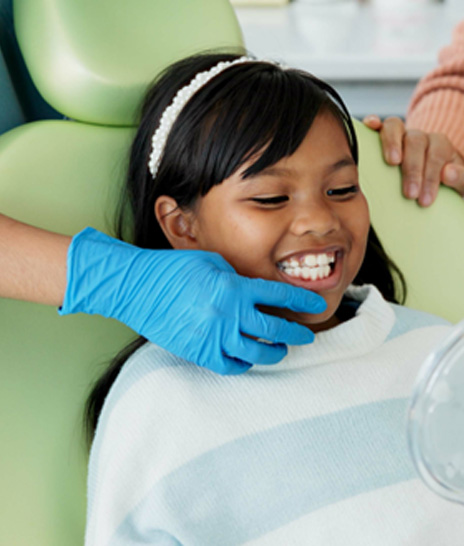 Child smiling while looking at reflection in mirror