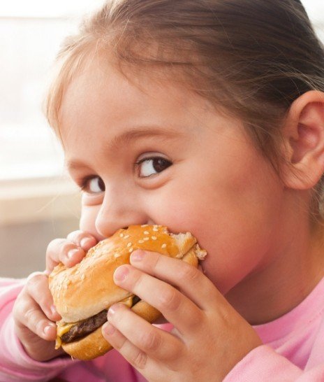 Young girl eating cheeseburger