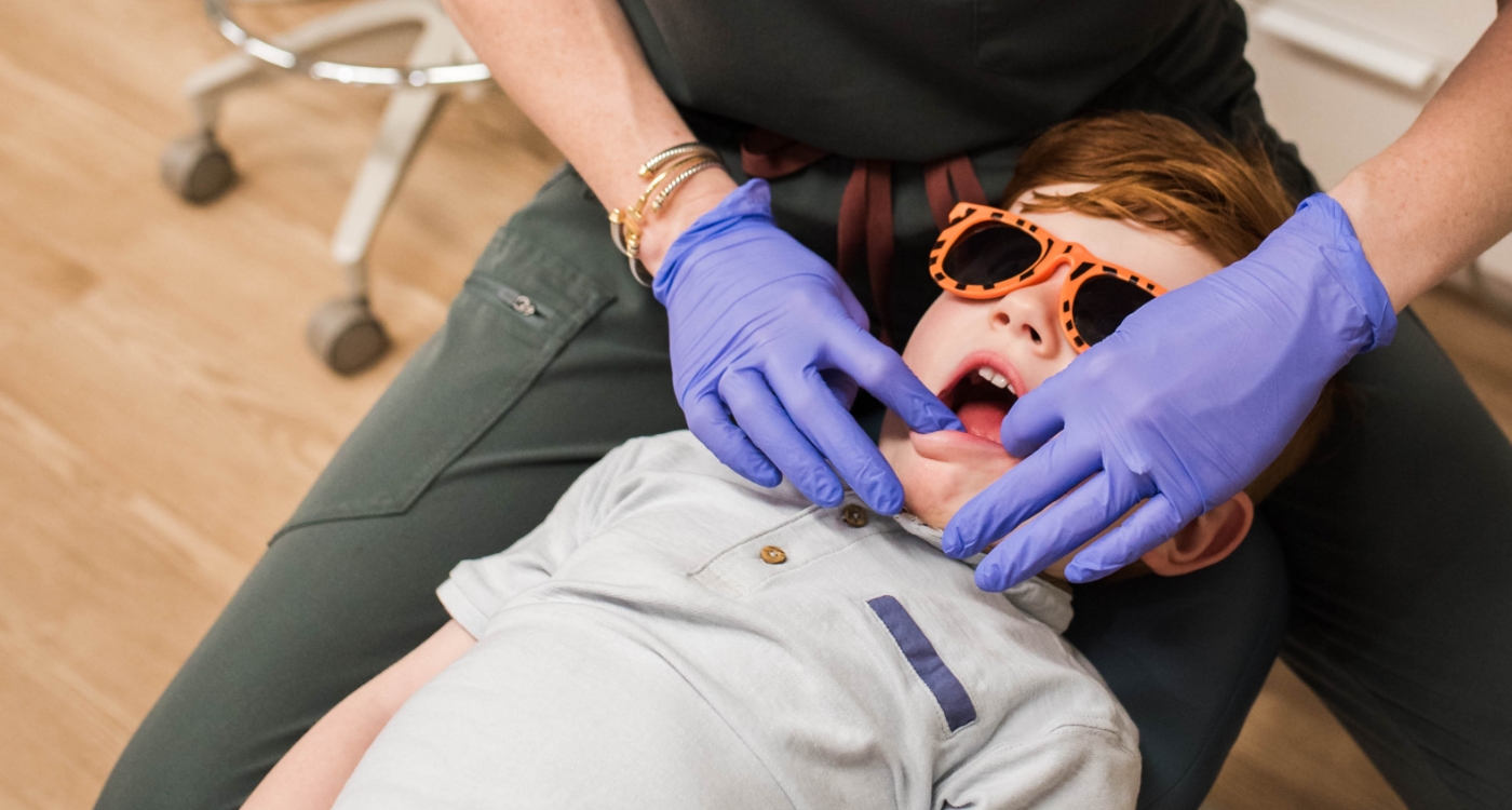 Young girl covering her mouth in pain before pulp and root canal treatment