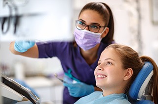 Child and dental team member looking at computer monitor