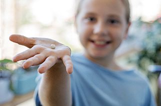 Young boy holding his extracted tooth