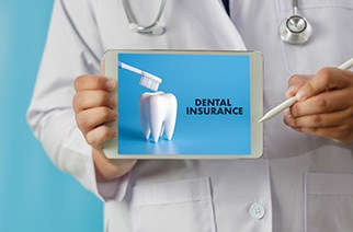 Dentist holding tablet with dental insurance information