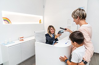 Mother and child standing at dental office front desk