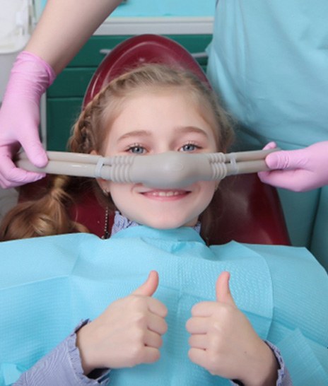 child getting nitrous oxide and giving a thumbs up