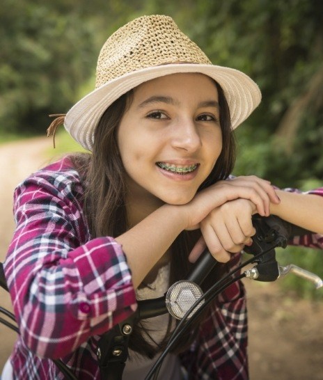 Teenage girl with braces sitting on bike