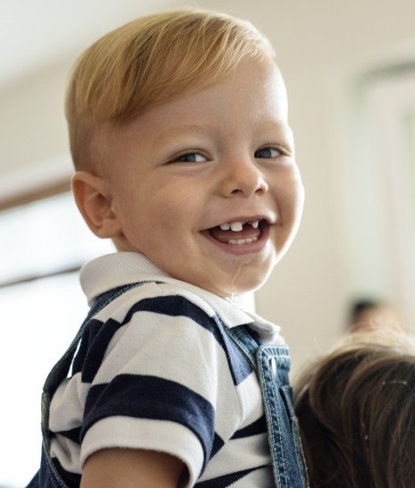Smiling toddler boy wearing overalls