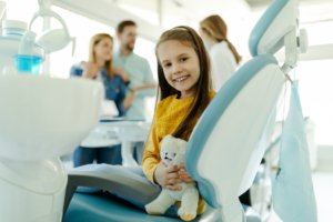 a child smiling while visiting her dentist