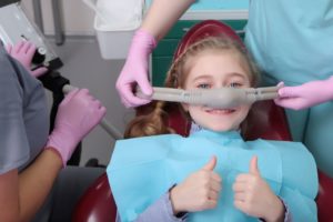 Little girl with nitrous oxide mask in dentist's chair