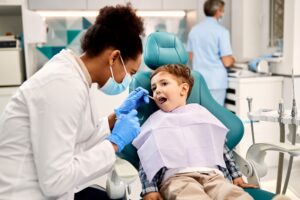 Dentist examining boy's teeth and gums