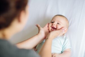 A person holding a baby’s face between their hands
